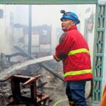 Petugas Unit Damkar Kabupaten Blitar menyemprotkan air ke rumah warga yang terbakar di Desa Slorok, Kecamatan Garum, Sabtu (22 Juni 2024)